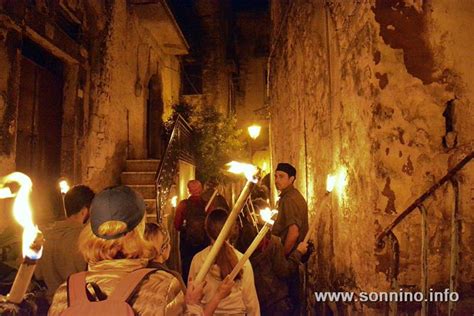 Foto notturna del rituale delle Torce a Sonnino, con una scia di luci che si snoda nel paesaggio.