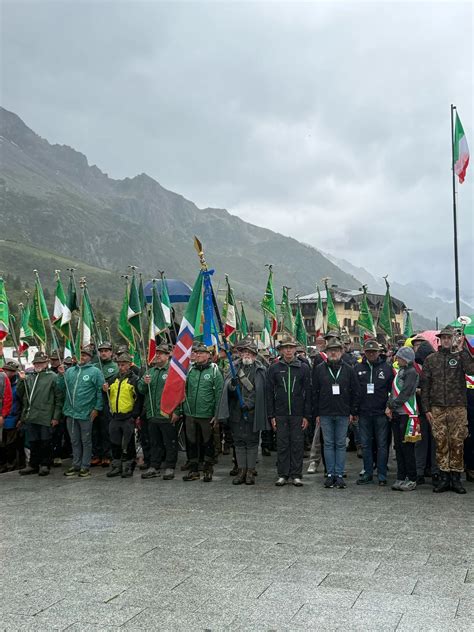 Foto di Alpini in marcia durante il pellegrinaggio in Adamello con uno sfondo montuoso