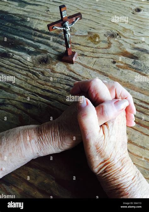 Persona che prega con un crocifisso o le mani giunte in un ambiente lavorativo o domestico