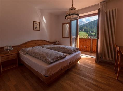 Interni di una camera dell'Hotel Dolomiti Cozzio con arredi in legno e vista panoramica