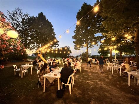 giardino estivo con tavoli all'aperto e palco per musica dal vivo