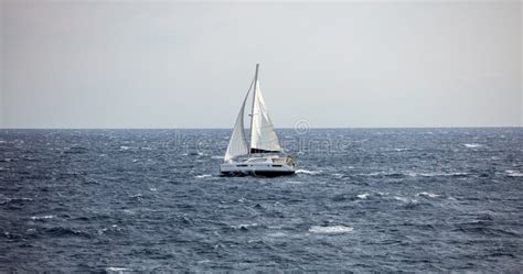 Vela gonfiata dal vento con mare in tempesta, metafora di fede