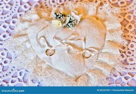 Immagine tematica di fedi nuziali su un cuscino, simbolo del dono del compare d'anello