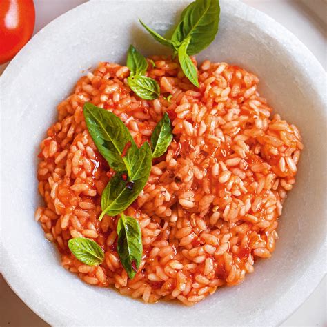 Piatto di riso al pomodoro e basilico appena pronto, guarnito con basilico fresco