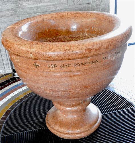 Fotografia di una vasca battesimale in rame del XVI secolo con dettagli dei piedini zoomorfi.