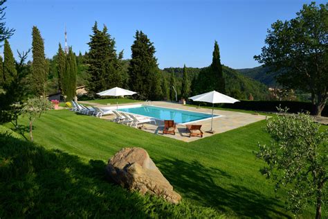 Piscina all'aperto dell'agriturismo con lettini prendisole e vista sulle colline
