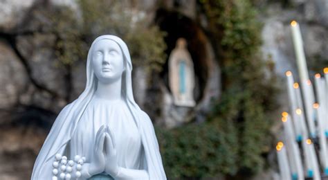 Foto della statua della Madonna di Lourdes che emette una luminescenza tenue in un ambiente buio