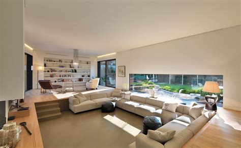 Interno del salone con ampie vetrate e vista sul giardino circostante