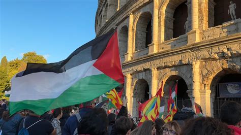 Giovani che sventolano bandiere e cappellini al Circo Massimo