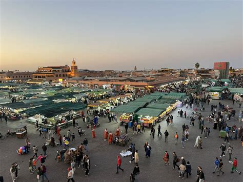 Veduta panoramica della piazza Jemaa el-Fna al tramonto con il minareto della Koutoubia sullo sfondo