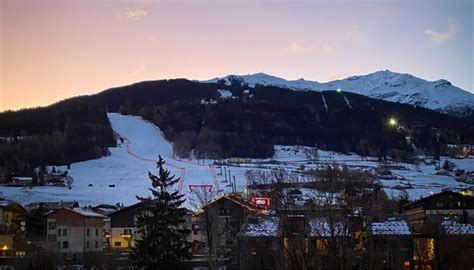 Panorama invernale di Bormio con le piste da sci illuminate e il centro storico sullo sfondo