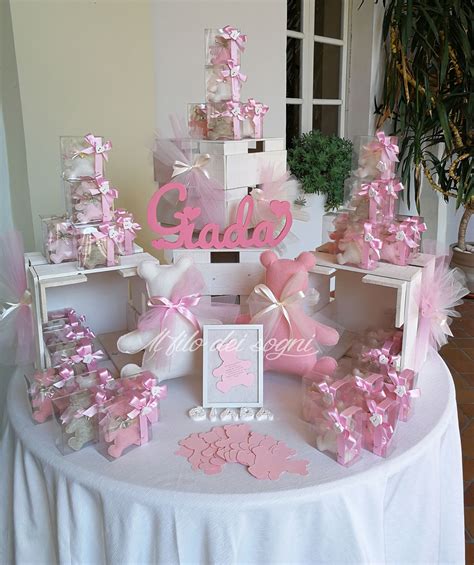 Foto di un tavolo allestito per una confettata battesimo bambina con decorazioni nei toni del rosa e bianco