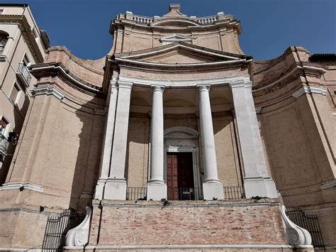Veduta frontale della facciata curvilinea della Chiesa del Gesù di Ancona, caratterizzata dal contrasto tra cotto locale e pietra d'Istria.