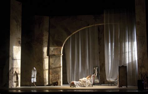 Scenografia dello spettacolo che mostra l'unione tra elementi del teatro classico e proiezioni multimediali di attualità.