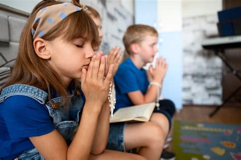 Bambini che pregano con i genitori durante il catechismo