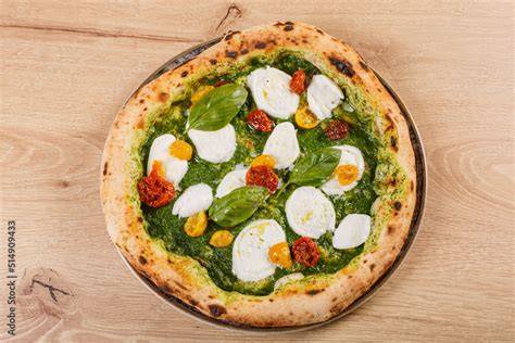 Pizza con pesto di basilico, pomodorini e mozzarella