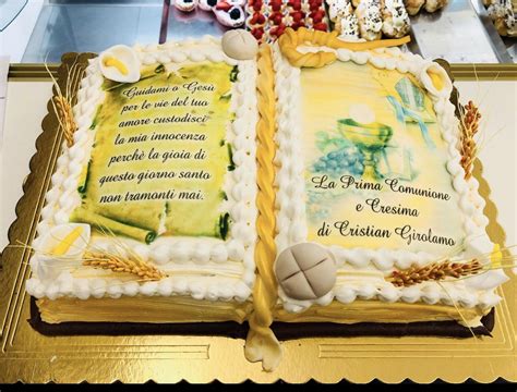Torta a forma di libro aperto con decorazioni sacre
