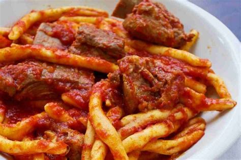 composizione di piatti tipici calabresi, tra cui stocco, parmigiana e paccheri alla 'nduja