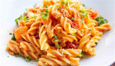 Primo piano di un piatto di fusilli al ragù con scaglie di pecorino