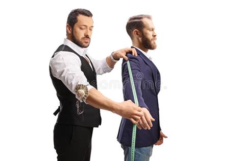 Un sarto napoletano mentre prende le misure di un cliente per un abito su misura.