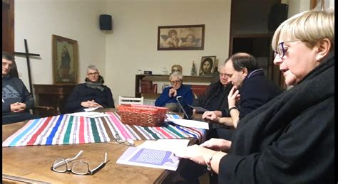 Sacerdote che dialoga e interagisce con un gruppo di parrocchiani di diverse età