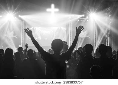 Gruppo di persone che adorano Dio durante un servizio religioso, con le mani alzate in preghiera
