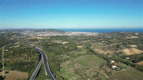 Vista panoramica delle colline marchigiane con vigneti e il mare Adriatico sullo sfondo