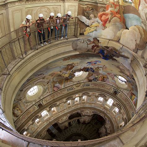 Interno della cupola di Vicoforte con affreschi e visitatori sul percorso