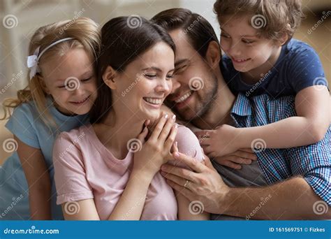 genitori sorridenti che abbracciano il figlio in un momento di festa