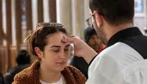 sacerdote che impone le ceneri sulla fronte di un bambino