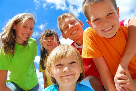 Bambini e ragazzi impegnati in attività di gruppo all'aperto, sorridenti e collaborativi