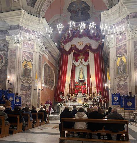 Foto di gruppo di fedeli che recitano il rosario in una chiesa