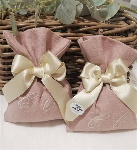 Dettaglio di un cestino porta bomboniere con nastri di raso, piccoli fiori e una targhetta personalizzata