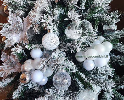Albero di Natale decorato con luci e addobbi in un giardino innevato