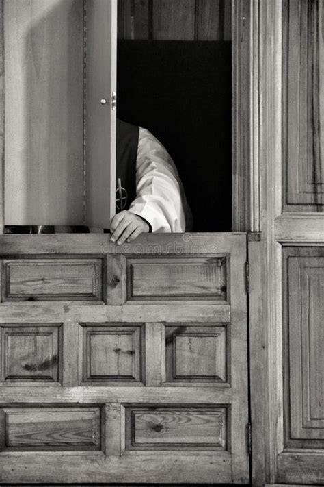 Sacerdote nel confessionale che ascolta un penitente