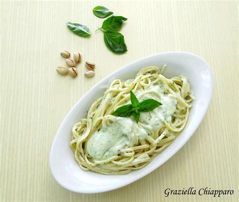 Foto di un piatto di pasta con ricotta e basilico, guarnito con foglie fresche di basilico e scaglie di mandorle