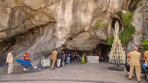 Grotta di Massabielle a Lourdes con fedeli in preghiera
