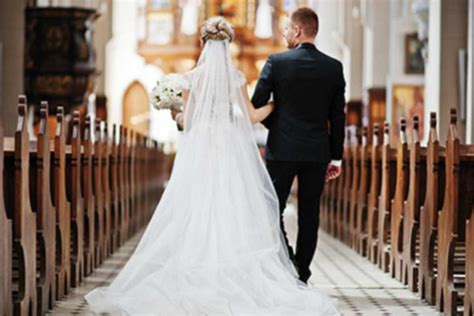 Coppia di sposi che si tengono per mano in chiesa durante la benedizione