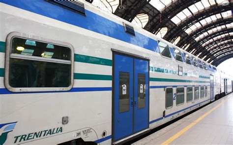 Fotografia di un treno fermo in stazione, con indicazioni di ritardo