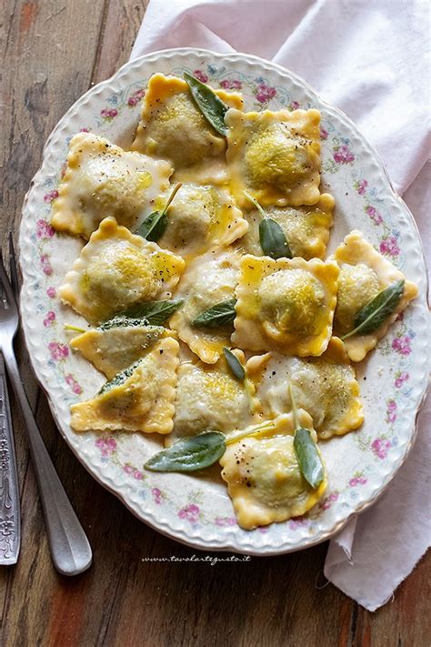 Mani che formano ravioli fatti in casa con ripieno di ricotta e basilico