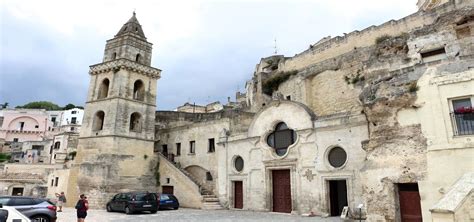 Foto panoramica della Chiesa di San Pietro Barisano nei Sassi di Matera, con evidenza della facciata in muratura e del contesto rupestre.