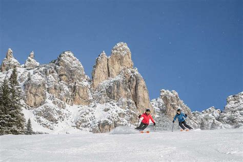 Foto di un comprensorio sciistico sulle Dolomiti con neve fresca e sciatori