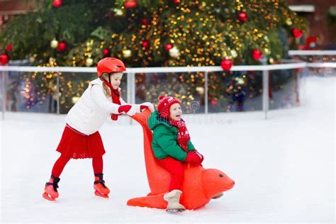 Foto di famiglia con bambini che pattinano sul ghiaccio in un mercatino di Natale