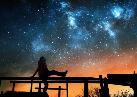 fotografia di un giovane che guarda il cielo stellato con espressione pensosa