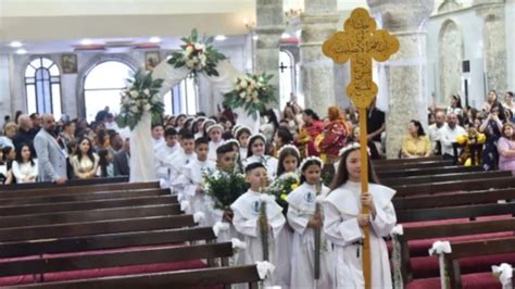 Bambini vestiti di bianco per la Prima Comunione in fila in chiesa