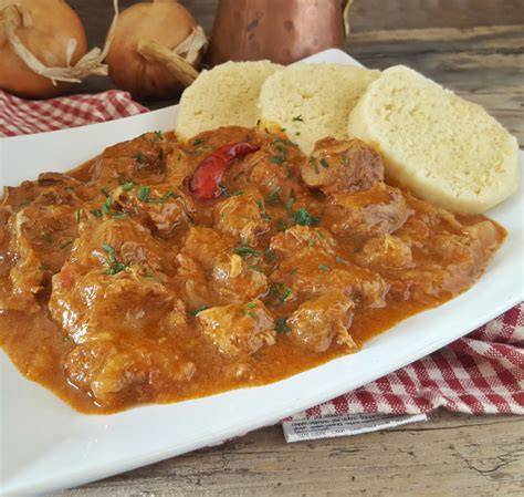 Piatto di gulasch con contorno e pane tradizionale, specialità altoatesina