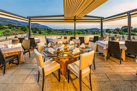 Terrazzo soleggiato di un ristorante con tavoli all'aperto e vista panoramica