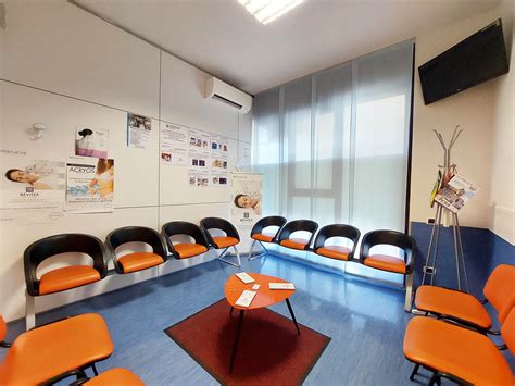 Immagine di una sala d'attesa moderna e digitale di un ambulatorio ASL, con schermi informativi.