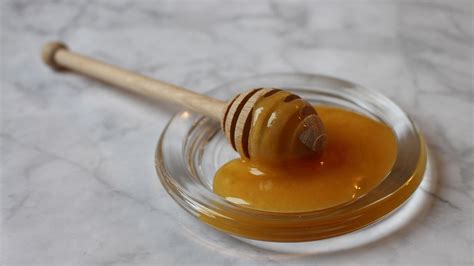 Disegno di un uomo che sigilla giare di miele e operazione di prelievo dei favi dagli alveari, con alveari orizzontali tipici della tradizione mediterranea.