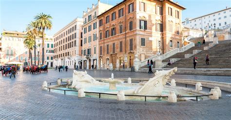 Una foto del monumento dell'Immacolata in Piazza di Spagna a Roma, con un cesto di fiori ai piedi della statua.